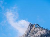 Wolkenfetzen umtanzen das verschneite Zellerhorn im Morgenlicht